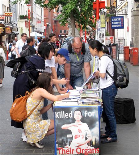 圖6：二零一九年六月一日，來倫敦旅遊的以色列一家四口人在倫敦唐人街一起簽名支持法輪功反迫害，法輪功學員溫迪向他們講真相。