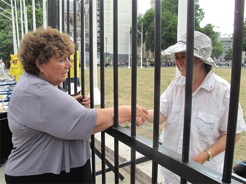 '圖13：「反迫害二十週年」， 法輪功學員在英議會大廈外展示真相，其中有對中共在大陸對法輪功學員非法關押監禁和殘酷迫害的模擬，英國會議員瑪麗﹒裏默（Marie Rimmer MP）到場支持法輪功學員反迫害'