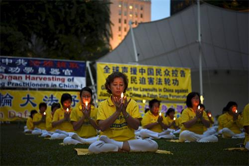 '圖5：入夜，學員們默默悼念二十年來為堅守正信被迫害致死的中國法輪功學員。'