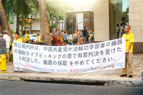 '圖4：夏威夷法輪功學員在日本遊客居多的商業步行街道上打出日文真相橫幅'