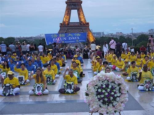 '圖1～2：二零一九年七月二十日傍晚，法輪功學員在巴黎人權廣場靜坐，紀念被中共致死的法輪功同修。'