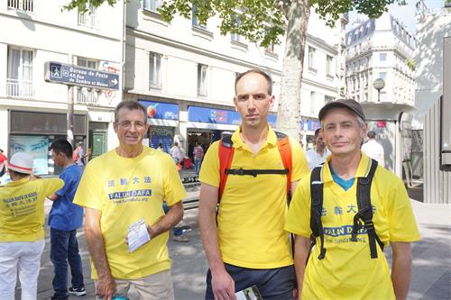 '圖4：法國新學員約瑟（左）、皮埃爾（中 ）和塞巴斯蒂安三位學員準備參加反迫害二十年遊行。'