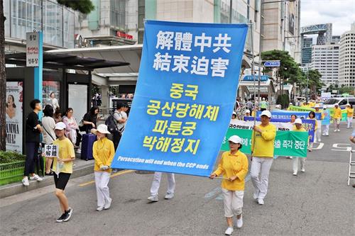 '圖24～30：法輪功遊行隊伍走在首爾樂天百貨店前。'
