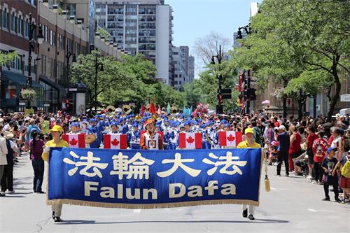 '圖1：加拿大國慶遊行是蒙特利爾規模最大的遊行慶祝活動之一，法輪功學員的遊行隊伍被觀眾稱讚。'