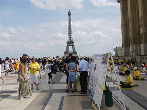 '圖1：二零一九年七月七日下午，法輪功學員在巴黎鐵塔邊的人權廣場，進行了法輪功功法演示、講真相、揭露中共迫害罪行及徵集簽名反迫害的活動。'