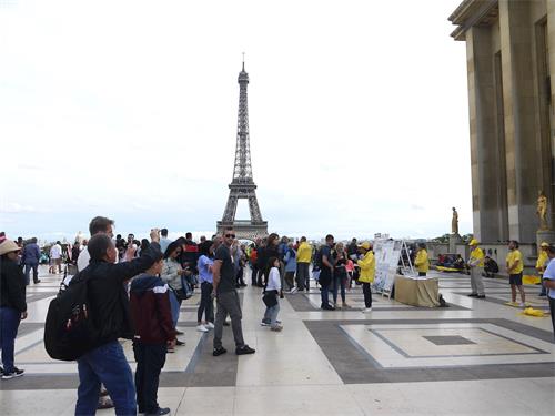 '圖1：八月十七日星期日下午，法輪功學員在巴黎人權廣場，進行了演示法輪功功法和講真相的活動，吸引各國遊人。'