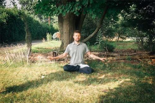 '圖2：奧利近日在紐約上州的一片草坪中靜坐修煉。'