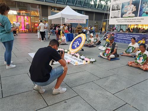 '圖1～2：2019年8月31日，法輪功學員在法蘭克福商業大道上舉辦燭光守夜活動，引來路人的關注'