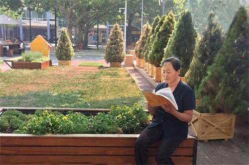 '圖：小玉正在閱讀法輪大法創始人李洪志大師的專著《轉法輪》'