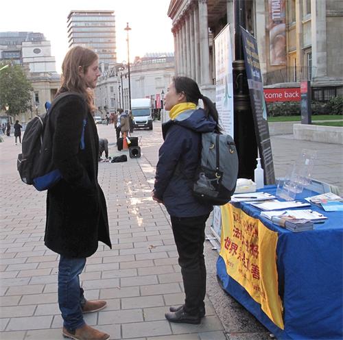 '圖10：二零二零年十月十日，英格蘭人查理﹒卡勒（Charle Calle）在倫敦特拉法加廣場與法輪功學員交談了解真相'