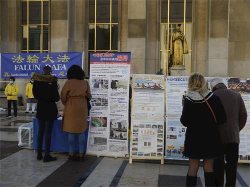 '圖1：遊人在巴黎人權廣場觀看法輪功真相展板'
