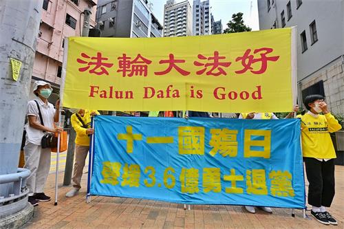 '圖1～2：十月一日，香港法輪功學員在中聯辦門外，舉起「法輪大法好」、「天滅中共」等標語。'