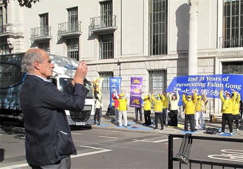 '圖4：二零二零年十月一日，法輪功學員在中使館前集體煉功的場面吸引了路過的倫敦醫生安東尼﹒希爾弗斯通（Anthony Silverstone）'