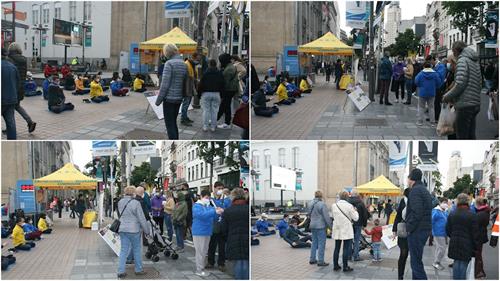 '圖1～2：法輪功學員在比利時安特衛普市商場林立的梅爾大街上舉辦講真相活動。'