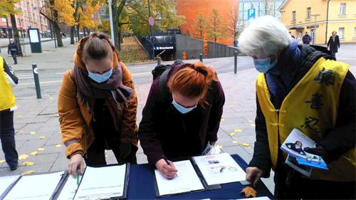 '圖1～2：芬蘭市民支持法輪功，簽名譴責中共暴行。'