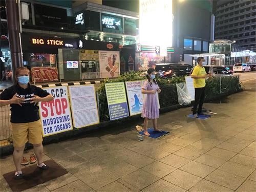 圖2：馬來西亞法輪功學員在吉隆坡市中心掛展板、煉功，向民眾講真相。