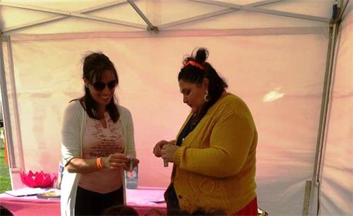 '圖9：法輪功學員索菲亞（左）在和一位女士一起製作小蓮花掛件，並在交談中分享自己的修煉體會和法輪功真相。'