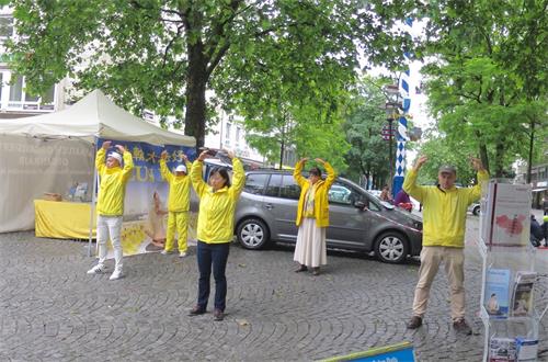 '圖4～5：德國慕尼黑法輪功學員在紅十字廣場（Rotkreuzplatz）展示功法演示。'