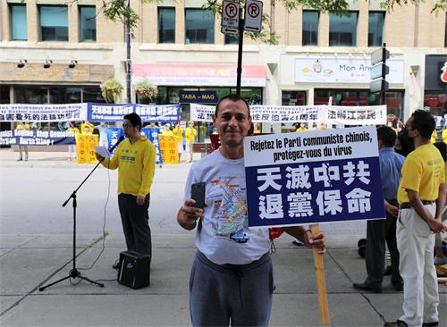 '圖6：蒙特利爾市民卡諾（Cano）舉起抗議牌子表達對法輪功學員的支持'