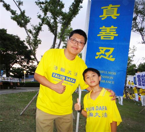 '圖14：林岳奇（左）表示，藉由參與活動，讓兒子（右）更深入了解法輪功，並珍惜修煉的機會。'