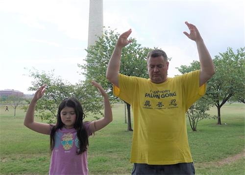 '圖10：德裔美國人紐曼（Bjorn Neumann）和女兒在華盛頓紀念碑前煉功。'
