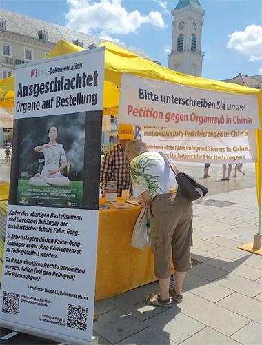 '圖1～2：二零二零年七月十八日，法輪功學員在德國西南部大城市卡斯魯爾（Karlsruhe）市中心的市場廣場（Marktplatz）舉辦信息日活動，圖為德國民眾簽名聲援法輪功反迫害。'