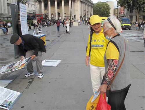 '圖11：當天的活動快結束時，一位住在唐人街的八十七歲華人梅珍女士走過來讚揚法輪功學員講真相活動做得好。'