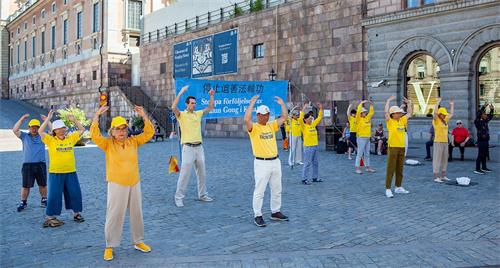 '圖1：二零二零年八月八日，法輪功學員在斯德哥爾摩市中心國會大廈旁的錢幣廣場，舉辦講真相活動。'