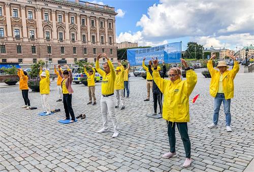 '圖1：2020年8月21日、22日和25日連續三天，法輪功學員在斯德哥爾摩市中心國會大廈旁的錢幣廣場舉辦講真相活動。學員在展示功法。'