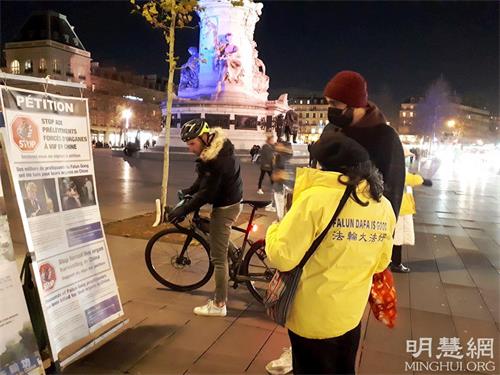 '圖2：二零二一年十二月十日，國際人權日當天，在巴黎共和國廣場，人們專注看展板，了解法輪功真相。'