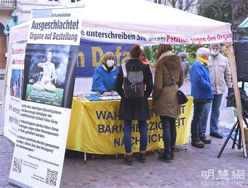 '圖1～2：二零二一年十二月十一日，法輪功學員在德國海德堡老城本生廣場（Bunsenplatz）舉辦活動，講述法輪功反迫害真相，揭露中共活摘器官的罪惡。'