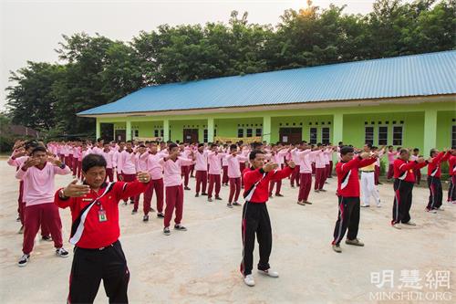 '圖7～8：阿爾加利亞職業高中（SEKOLAH MENENGAH KEJURUAN ALJABAR）老師和學生和巴丹島法輪功學員一同煉功。'