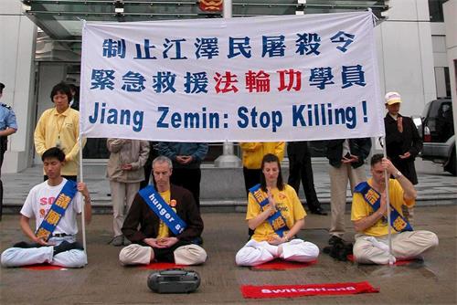 '圖2：二零零二年三月十四日，四名瑞士和十二名香港的法輪功學員在西區中聯辦前絕食靜坐，抗議中共迫害殘殺大陸法輪功學員，遭警方武力粗暴抬走。'