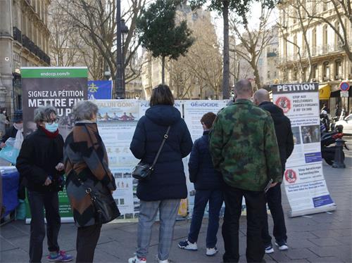 '圖1～2：二月二十七日下午，法輪功學員在巴黎聖米歇爾廣場（Place Saint Michel）進行了講真相和徵簽的活動'
