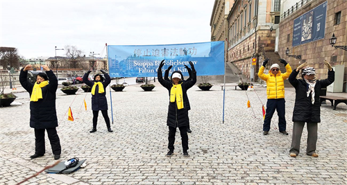 '圖1：法輪功學員在瑞典國會大廈旁的錢幣廣場，舉辦講真相活動。學員在展示功法。'