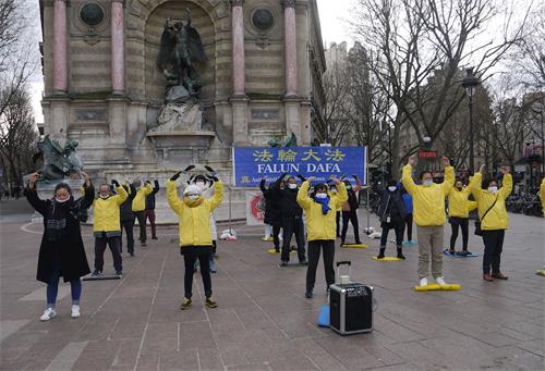 '圖1～2：二零二一年三月二十一日星期日下午，在巴黎聖米歇爾廣場，法輪功學員舉辦了煉功、講真相和徵集簽名反迫害的活動。'