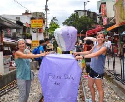 圖2：珍妮﹒米切爾（Jeanne Mitchell，左）在台灣平溪燃放寫著「法輪大法好」的天燈。