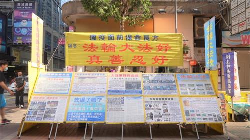 '圖1～2：雖然多次遭到中共暴徒襲擊，但香港法輪功學員沒有退卻，真相點一天都沒有停止過。圖為四月二十三日位於旺角豉油街的法輪功真相點。'