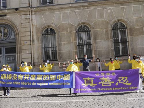 '圖1～2：法輪功學員在巴黎中使館前舉行集會，告訴人們法輪功真相，揭露中共二十多年來對法輪功的殘酷迫害。'