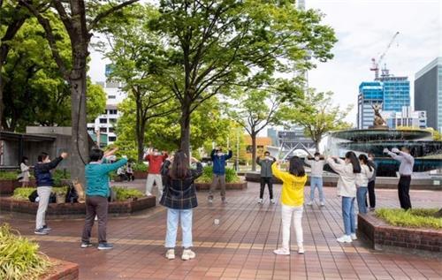 '圖1：法輪功學員在日本名古屋市（Nagoya-City）中心的繁華地段煉功，向民眾介紹功法。'