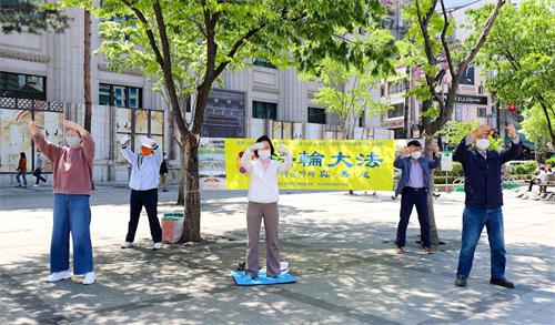 '圖5：韓國法輪功學員在駐韓中共大使館附近集體煉功。'