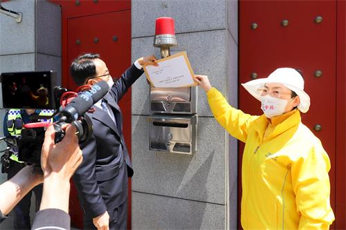 '圖6：記者會結束時，韓國法輪大法佛學會代表將聲明書投入駐韓中共大使館的信箱。'