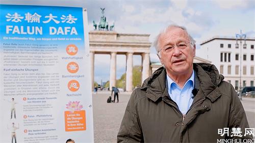 圖5：德國國會議員帕策爾特（Martin Patzelt）在柏林勃蘭登堡門前，向法輪功學員祝賀世界法輪大法日。
