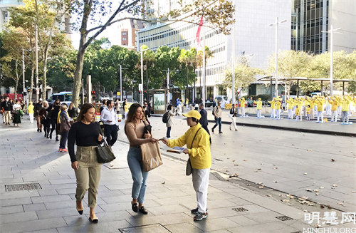 圖1～2：匆匆趕著上班的主流人士被一片祥和的場面吸引，悉尼法輪功學員正迎著朝霞集體晨煉