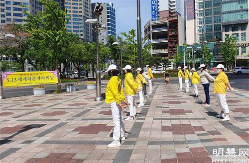 圖23:韓國蔚山學員在樂天百貨公司北廣場集體煉功洪法慶祝世界法輪大法日。