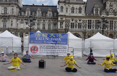 '圖1：法輪功學員在巴黎市政廳廣場煉功打坐'