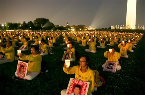'圖6～7：夜幕降臨，學員們舉起燭光，悼念在中國大陸因堅持信仰被迫害致死的法輪功學員。'