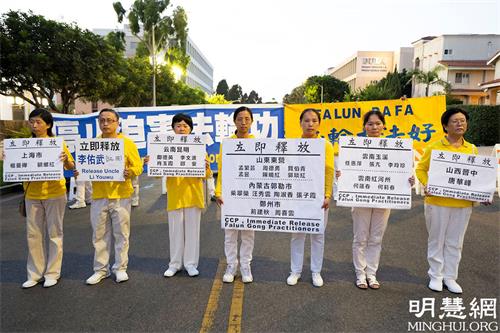 '圖9：集會上，部份來自中國大陸的法輪功學員手舉營救展板，呼籲釋放所有被非法關押的法輪功學員。'