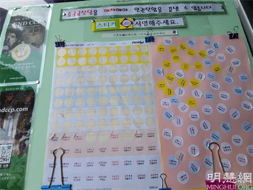 '圖8：在中共病毒導致全球大流行的當下，越來越多的韓國人開始對中共感到反感。了解真相後的市民，把「天滅中共」的貼紙貼到貼板表示支持學員發迫害。'