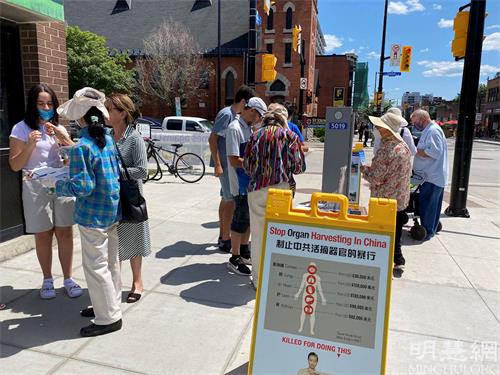 '圖1～2：渥太華人在市中心的街道上，通過簽名等方式表達對法輪功的支持。'